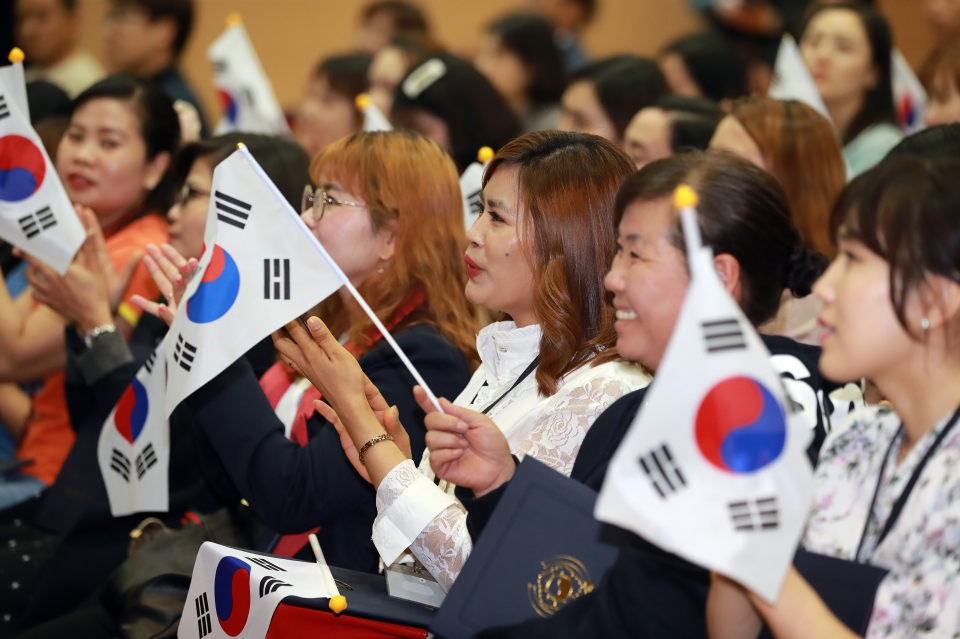 23일 오후 경산시 대구가톨릭대학교 성바오로관에서 열린 ‘대한민국 국적증서 수여식’에 참석한 귀화자들이 태극기를 흔들며 '아! 대한민국'을 함께 부르고 있다. 이날 100명이 대한민국 국적을 새로 취득해 개정된 국적법에 따라 지금까지 대구·경북 시·도민이 된 사람은 총 301명에 달한다. 대구시·경북도와 대구출입국외국인사무소는 국적 취득과 동시에 지역 시·도민이 되는 의미를 더욱 빛내기 위해 4월 국적증서 수여식부터 새로운 축하행사를 개최한다. 뉴스1