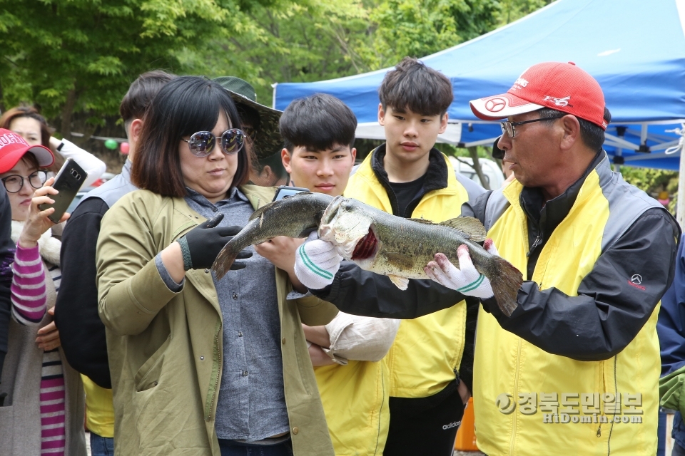 대회 참가자들이 잡힌 외래어종을 들고 보고 있다.