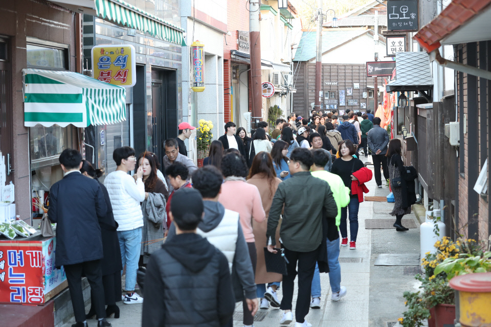 최근 끝난 KBS 수목드라마 ‘동백꽃 필 무렵’의 여파로 요즘 구룡포에는 구름인파가 몰리고 있다. 드라마 촬영지인 일본인 가옥거리 ‘문화마실’ 앞에는 인증샷과 음식을 맛보려는 관광객들로 하루종일 붐빈다. 구룡포읍에 따르면 지난 주말과 휴일에 6000~7000명, 평일에도 3000명이 이상이 구룡포를 찾았다. 사진은 휴일이었던 지난달 24일 구룡포 일본인 가옥거리를 찾은 외지인들이 드라마 촬영지를 둘러보고 있다. 뉴스1