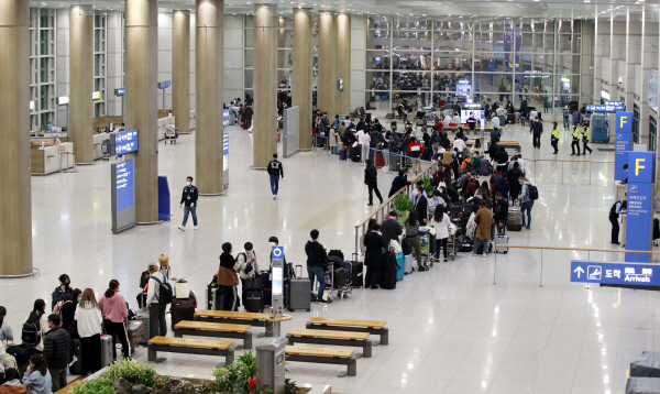 22일 오후 유럽발 입국자들이 인천공항을 통해 귀국해 검사를 위해 길게 줄을 서 있다. 뉴스1
