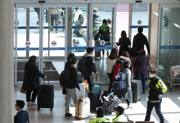 24일 인천국제공항 1터미널에서 아랍에미리트 아부다비발 여객기를 타고 입국한 승객들이 신종 코로나바이러스 감염증(코로나19) 진단 검사를 받기 위해 이동하고 있다. 뉴스1