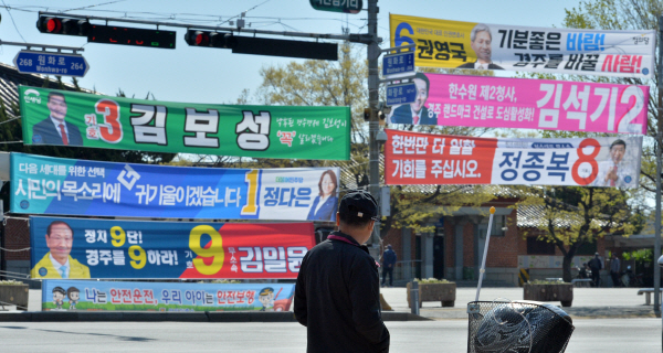 4.15총선 사전투표일을 이틀앞둔 9일 경북 경주역 교차로에서 신호를 기다리는 시민이 지역 국회의원 후보들의 현수막을 지켜보고 있다. 뉴스1