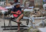 초특급 태풍 하이옌의 급습으로 폐허가 된 필리핀 레이테주 다가미에서 한 남자가 20일(현지시간) 기타를 치고 있다. 하이옌이 지나간 뒤 필리핀에서는 400만명 이상의 이재민이 발생, 주거지와 식량 등의 부족으로 고통을 겪고 있다. 연합