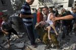29일(현지시간) 팔레스타인 가자지구 칸 유니스에서 4층 높이의 아파트가 이스라엘군의 공습을 받아 파손된 가운데 건물 잔해 아래에서 발견된 어린아이를 주민들이 옮기고 있다. 연합