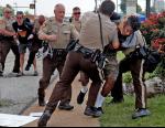 10대 흑인청년 경찰총격 사망 사건이 발생한 미국 미주리주 퍼거슨시에서 18일(현지시간) 경찰이 군중집회장 인근을 지나가던 남자에게 집회장으로는 가지말 것을 요구하다 시비가 붙자 남자를 땅바닥에 눕히려 하고 있다. 연합