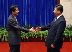 시진핑 중국 국가주석(오른쪽)과 아베 신조 일본 총리가 10일(현지시간) 베이징 댜오위타이에서 악수를 나누려고 손을 내밀고 있다. 연합