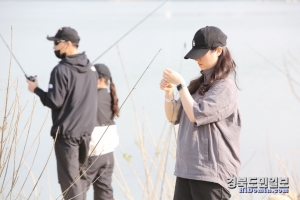 여성 참가자가 낚시 바늘에 미끼를 끼우느라 열중하고 있는 모습.
