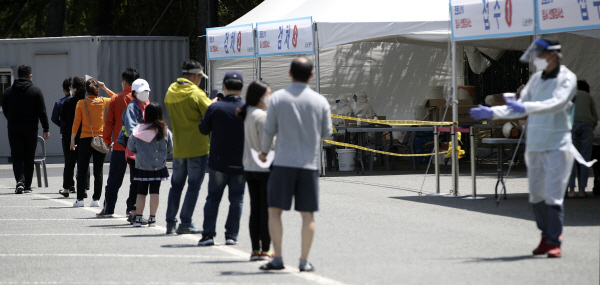 울산지역에 신종 코로나바이러스 감염증(코로나19) 변이 바이러스 확산세가 이어지고 있는 5일 울산 남구 문수축구경기장에 마련된 임시 선별검사소를 찾은 시민들이 검사를 받기 위해 줄지어 서 있다. 뉴스1