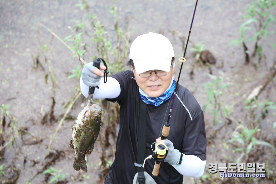 한 참가자가 잡은 물고기를 들어 보이고 있다.