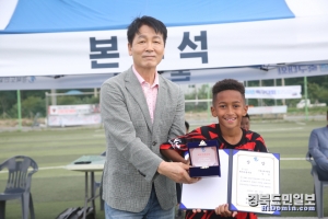 황병기 포항시축구협회 부회장이 대회 U-10 MVP를 수상한 알툴 이형상클럽 선수에게 상패를 전달하고 있다.