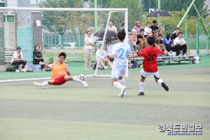 골키퍼가 강력한 상대 공격수의 슈팅을 막아내고 있다.