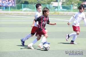 한 선수가 수비수 사이로 공을 드리블하고 있다.
