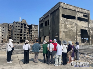 지난 11일 ‘한일문화포럼’ 회원들에게 해설사가 정면에 보이는 하시마 탄광의 일본인 직원 숙소인 일본 최초의 아파트를 설명하고 있다.