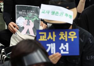 22일 오후 서울 종로구 보신각 앞에서 전국교사모임 주최로 열린 서초 서이초 교사 추모식 및 교사생존권을 위한 집회에서 참가자들이 손팻말을 들고 있다. 뉴스1
